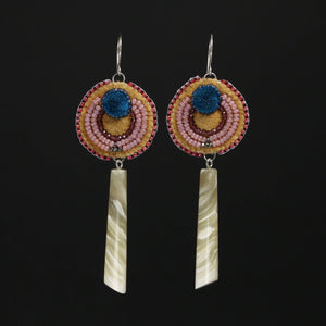 Beaded, tufted and muskox horn earrings on a black background