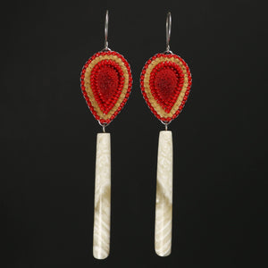 Red beaded and Tufted Muskox earrings on a black backgrounf